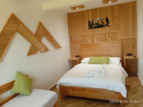 two beds in a room with wooden walls at Le Gite du Barrage in Zaouia Ben Smine