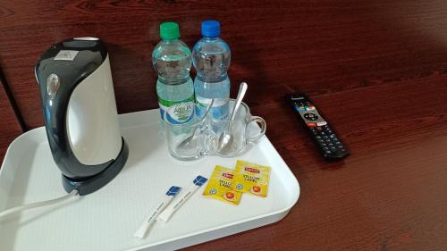 a table with two bottles of water and a remote control at Noclegi Gambit Cieszyn 24h in Cieszyn