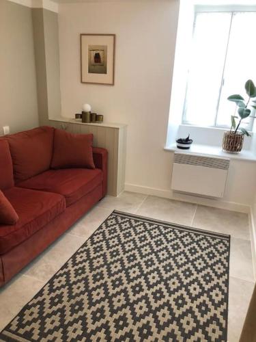 uma sala de estar com um sofá vermelho e um tapete em Charmant Duplex au centre de La Rochelle em La Rochelle