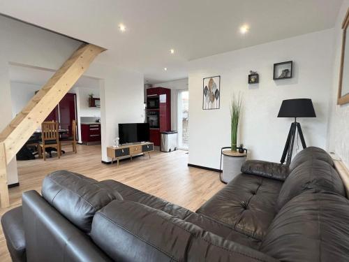 un salon avec un canapé en cuir marron dans un salon dans l'établissement Gîte gravelines, à Gravelines