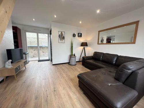 un salon avec un canapé en cuir et une télévision dans l'établissement Gîte gravelines, à Gravelines