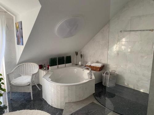 Residenz Jäger في لوهْفيلدِن: حمام أبيض مع حوض استحمام وكرسي