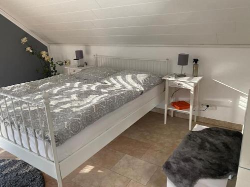 ein Schlafzimmer mit einem Bett und einem Nachttisch mit einem Tisch in der Unterkunft Residenz Jäger in Lohfelden