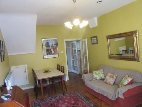een woonkamer met een bank en een tafel bij Cathedral Cottage in Derry Londonderry