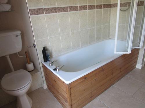 een badkamer met een bad en een toilet bij Cathedral Cottage in Derry Londonderry