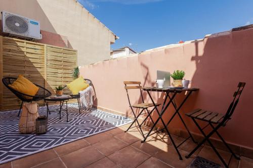 a patio with chairs and a table on a balcony at Nordik Rooms Urban - Centro "Estocolmo" in Málaga