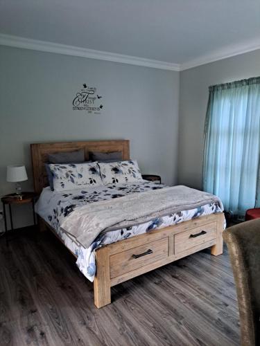 a bedroom with a bed with a wooden bed frame at Charis on Beaumont Home in Ramsgate