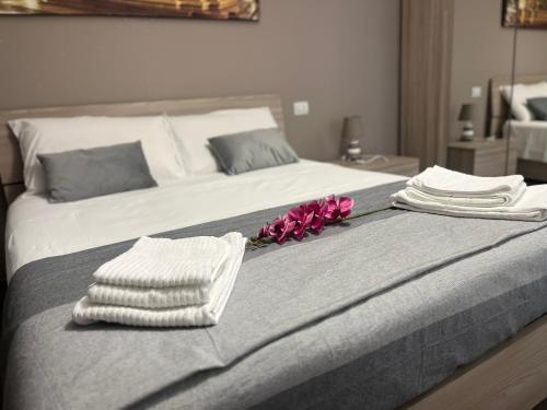 a bed with towels and flowers on top of it at Sweet Home 051 in Bologna