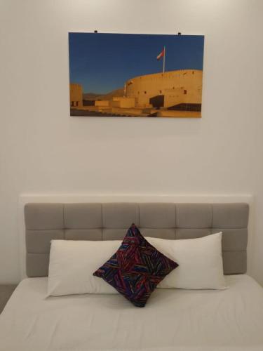 un letto con due cuscini sopra di MY HOTEL Al Lathba Pool Villa - Nizwa فيلا اللثبه-نزوى a Nizwa