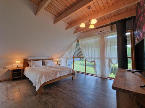 - une chambre avec un lit et une grande fenêtre dans l'établissement Roksala, à Taručiai