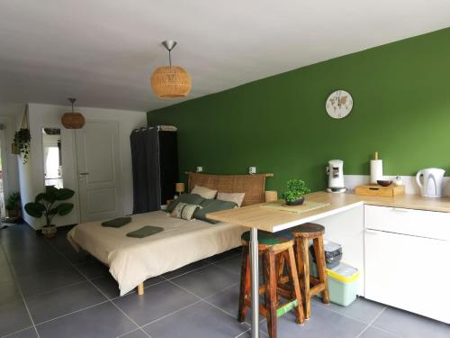 ein Schlafzimmer mit einem Bett und einer grünen Wand in der Unterkunft Les lits de l'Arz in Malansac