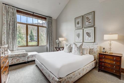 a bedroom with a large white bed and a window at The Arrabelle at Vail Square, a RockResort in Vail