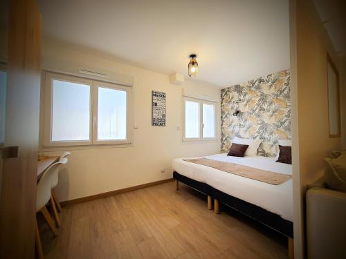 a bedroom with a bed and two windows at Cosy Aulnay-Paris Nord -Expo Villepinte in Aulnay-sous-Bois