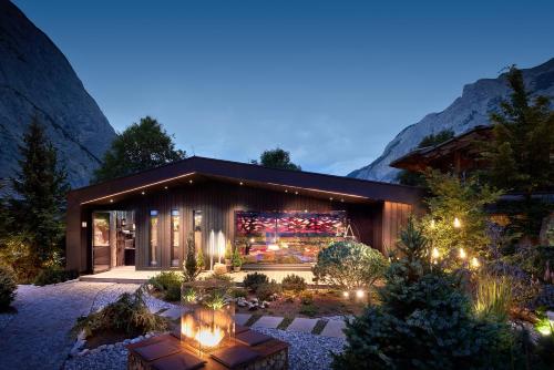 a house with lights in a garden at night at Gramai Alm alpengenuss & natur spa in Pertisau