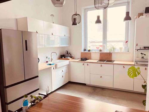 uma cozinha com armários brancos e uma grande janela em Luxus Loft im Herzen von Bochum Werne. em Bochum