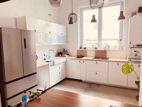 a kitchen with white cabinets and a large window at Luxus Loft im Herzen von Bochum Werne. in Bochum