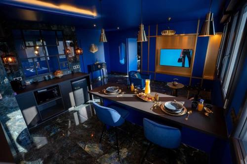 une cuisine bleue avec une table et des chaises bleues dans l'établissement Minka, à Corbas