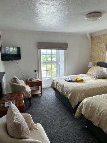 ein Hotelzimmer mit 2 Betten und einem Fenster in der Unterkunft Holland arms hotel in Llangristiolus