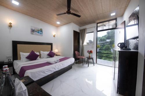 a bedroom with a bed and a large window at PerfectPlus Mussoorie in Mussoorie