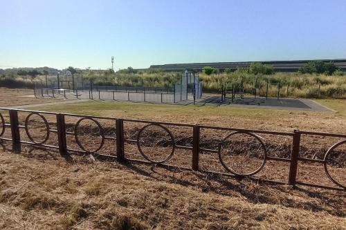 a fence in front of a park with a playground at studio sympa au rez de chaussée in Denain