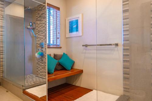 a shower with a glass door in a bathroom at Beachfront Luxurious Stunning Sunset Boulevard Apartment, Grand Baie in Grand Baie