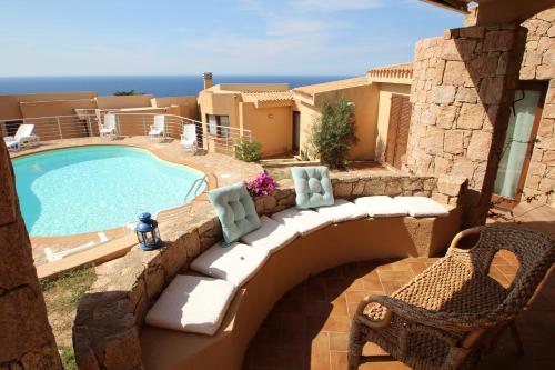 vistas a la piscina y a un patio con banco y piscina en Residence La Cala infinityholidays, en Costa Paradiso
