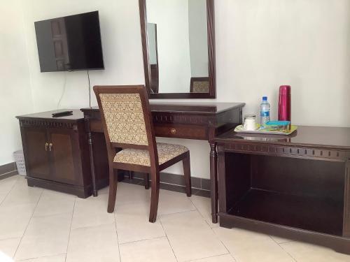 a wooden desk with a chair and a mirror at HOTEL HIPPO BUCK in Homa Bay