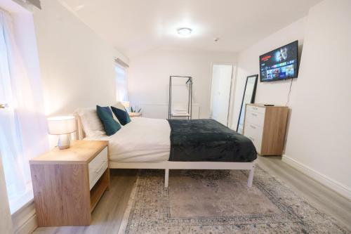 1 dormitorio con 1 cama y TV en la pared en Seafront Retreat Studio Flat Cleethorpes Beach, en Cleethorpes