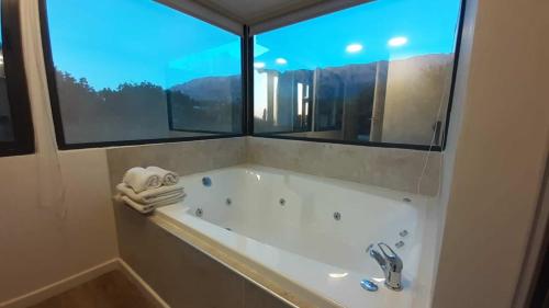 y baño con bañera y ventana. en Altos del Sol - Spa & Resort en Merlo