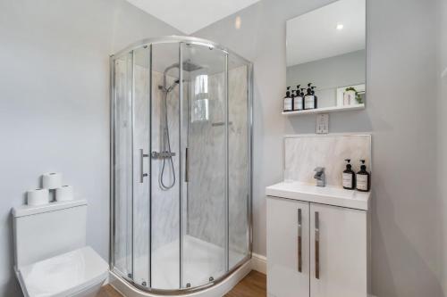 a white bathroom with a shower and a sink at Private En-suite Double Rooms - 5 Minute Walk to Hendon Central Station - Reach Central London in just 21 Minutes in Golders Green
