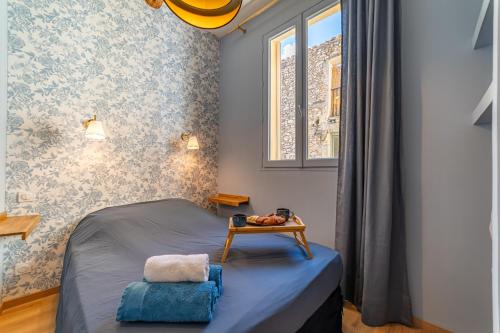 a small bedroom with a bed and a table at Le bleu Jean Denim Arènes - Une Nuit à Nîmes in Nîmes