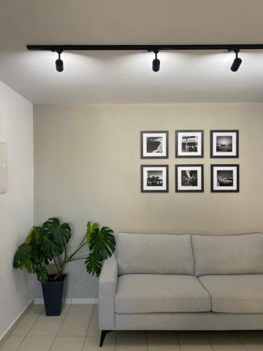 a living room with a couch and pictures on the wall at Sea La Vie #1 - Luxury Seaview apartment in Paphos