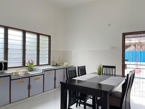 eine Küche mit einem Tisch und Stühlen im Zimmer in der Unterkunft Comfort Semi D House, 1 min to Town by Mr Homestay in Teluk Intan
