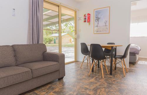 a living room with a couch and a table and chairs at Penola Coonawarra Caravan Park in Penola