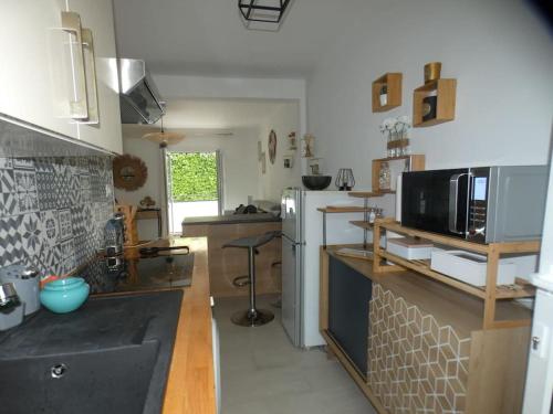 eine Küche mit einem weißen Kühlschrank und einer Mikrowelle in der Unterkunft Studio avec jardin proche plage Six Fours/Sanary in Six-Fours-les-Plages