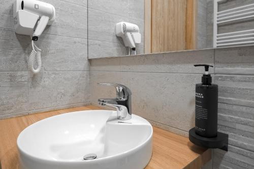 a bathroom with a sink and a hair dryer at Hotel Cascada BAILE OLANESTI in Băile Olăneşti