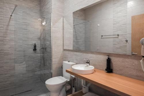 a bathroom with a toilet and a sink and a shower at Hotel Cascada BAILE OLANESTI in Băile Olăneşti