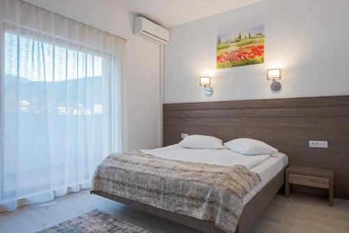 a bedroom with a bed and a large window at Hotel Cascada BAILE OLANESTI in Băile Olăneşti