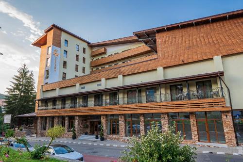 a large building with a balcony on the side of it at Hotel Cascada BAILE OLANESTI in Băile Olăneşti