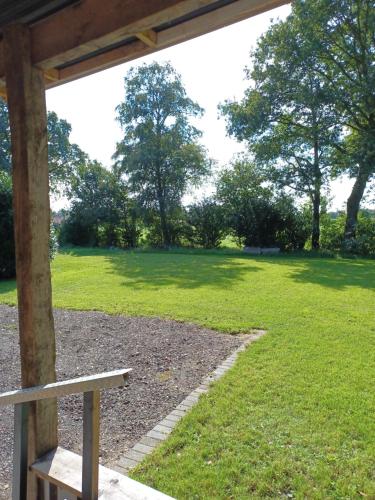 a bench in a park with a grass field at Pak oe rust, bij stacaravan Busscher in Geesteren