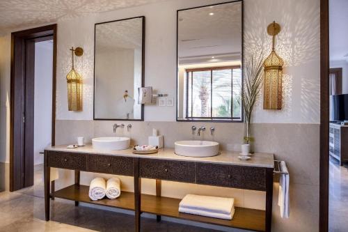La salle de bains est pourvue de 2 lavabos et d'un grand miroir. dans l'établissement The Residence Douz, à Douz