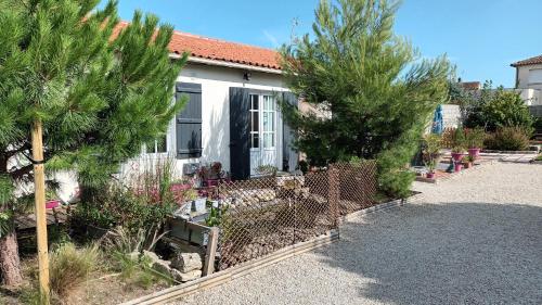 a house with trees and a fence in front of it at Le Clos des Passiflores in Pons