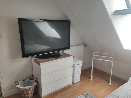 einen Flachbild-TV auf einer Kommode in einem Zimmer in der Unterkunft Chambre chez l'habitant in Châteaubriant