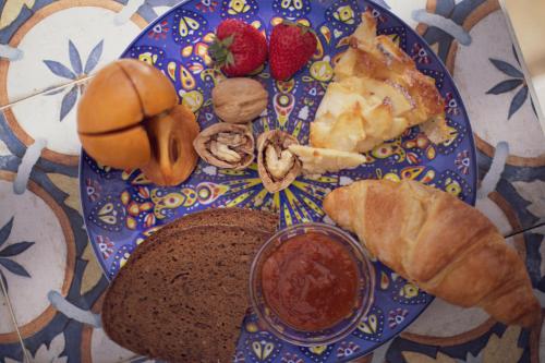 a plate of food with bread and strawberries on a table at Corte Di Ferro Hotel & Wellness Resort in Carovigno