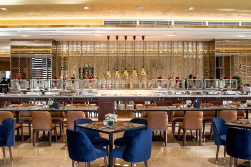 ニャチャンにあるBest Western Premier Marvella Nha Trangのテーブルと椅子とバーのあるレストラン