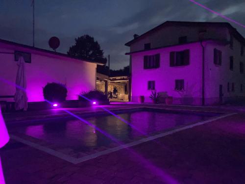 Borgo TossignanoにあるCa’ Vanelloの駐車場の紫色の灯りを持つ家