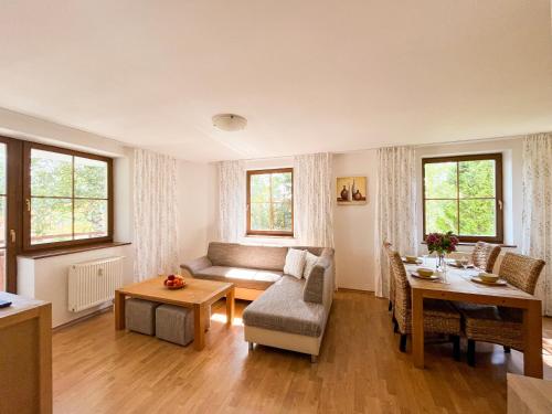 een woonkamer met een bank en een tafel bij Slnečný 2-izbový apartmán Pod lesom, Dolný Smokovec in Vysoké Tatry