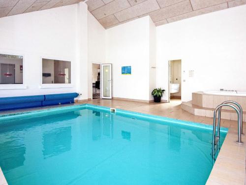 a large swimming pool with blue water in a building at 10 person holiday home in Grenaa in Grenå