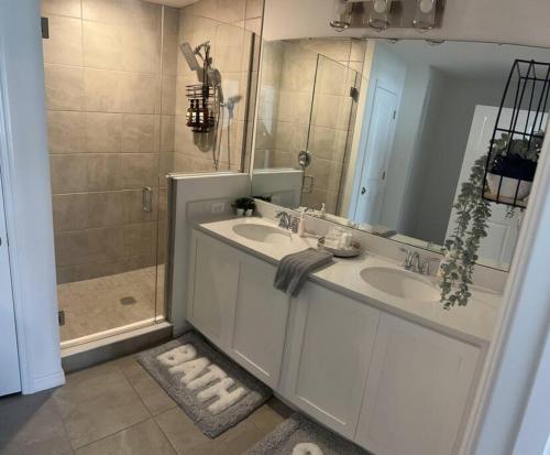 a bathroom with two sinks and a shower at FREE Amenities with Kids Waterpark in Luxury House in Davenport
