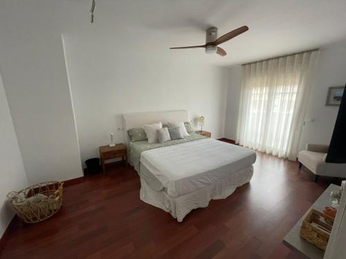 a white bedroom with a bed and a ceiling fan at Tokyo Rooms (El Playazo) - Habitación PREMIUM con baño privado in Almería